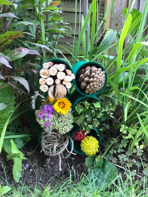 Bee and bug house in a flowerbed 