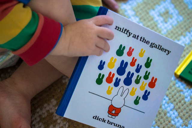A close up of a small child holding the miffy at the gallery book