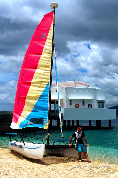 Yodi souvenir photo at the Bellarocca Resort Dock area on a boat with colorful sails. 