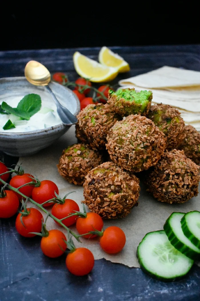 Crisp green falafel made with edamame beans, peas and coriander and served with a yoghurt, cucumber and mint dip. This recipe is easy to make at home and suitable for vegetarians or vegans.
