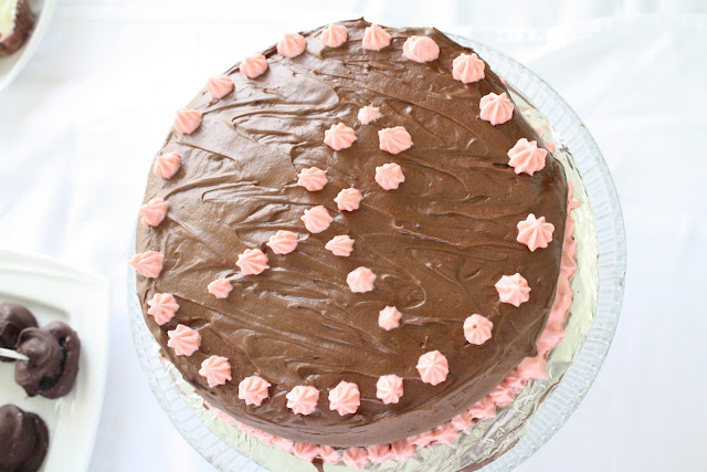 Top down shot of a chocolate frosted cake with pink icing. 