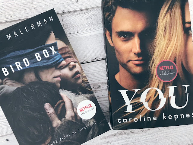 Two books with movie or tv images on the cover, one titled You and the other Bird Box