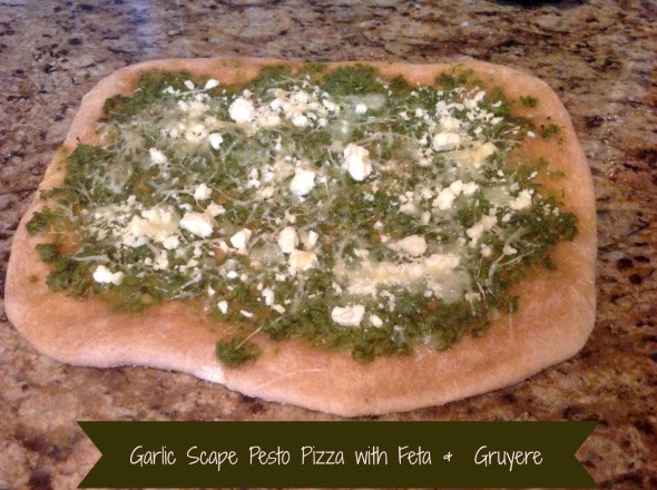 photo of garlic scape pesto pizza with feta and gruyere, one of the recipes from the garlic scape recipe round up