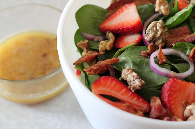 This spinach salad is topped with fresh strawberries, red onions, candied nuts, and a hot bacon dressing you won't get enough of!