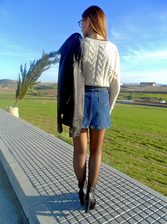 Falda denim acamapanda, jersey de punto rasgado, cazadora biker negra y botines de tacón con hebillas