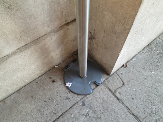 A pole which holds a ribbon guide for people in a queue