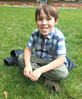 A Boy in a Field Boy sitting cross legged in a field.
