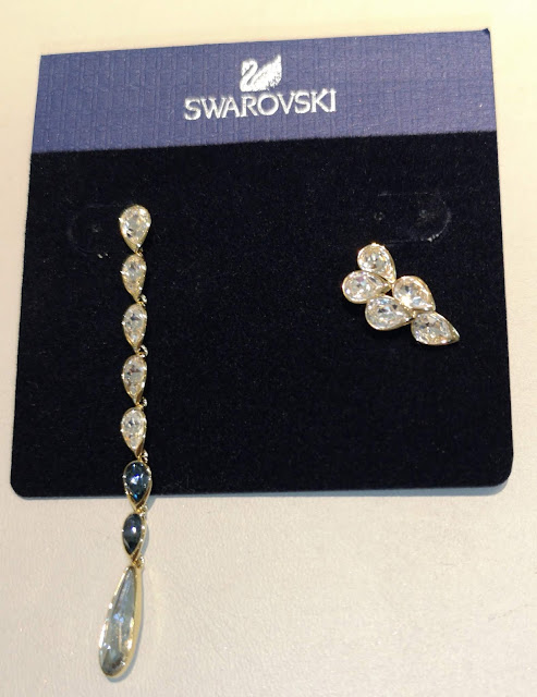 Orecchini Swarovski diversi, uno pendente e uno no, in metallo dorato con gocce di cristallo bianche e blu. Da abbinare al modello della foto precedente. A saldo.