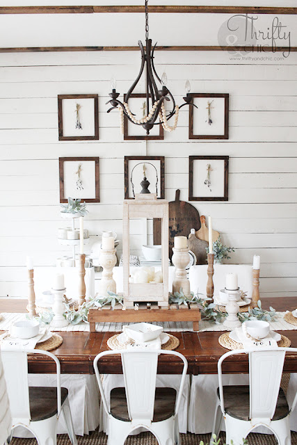 dining room with wood table, white metal chairs, white slipcover chairs, shiplap wall and wood gallery wall.