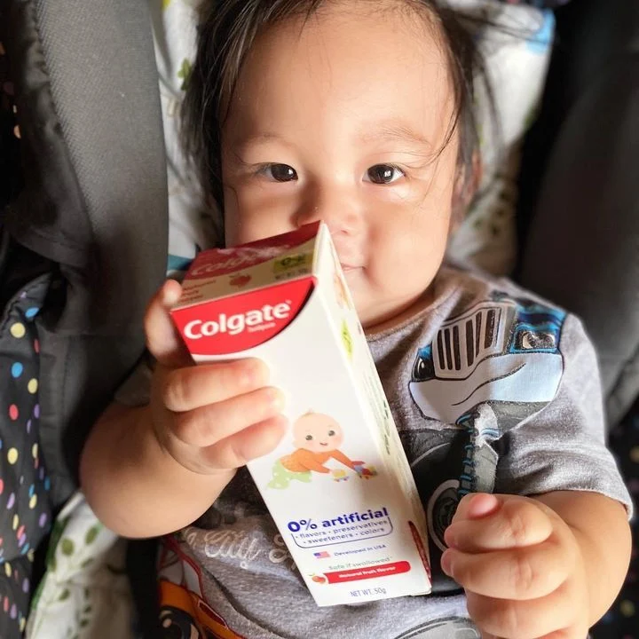 Baby holding a Colgate kiddie toothpaste to instill the habit of good oral hygiene