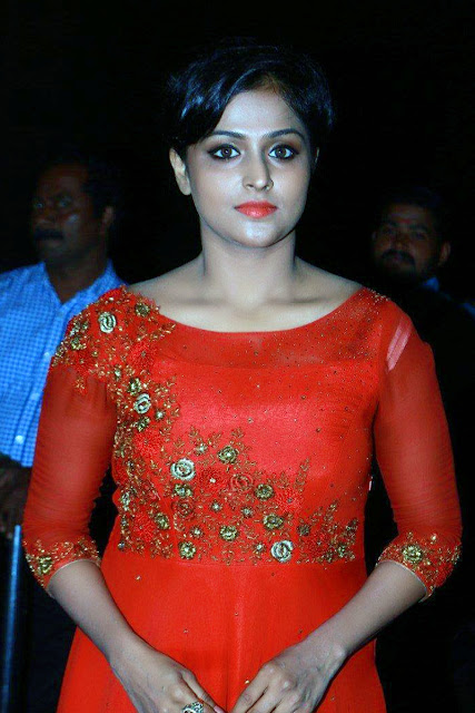 HEROINE REMYA NAMBEESAN IN LONG RED DRESS AND STANDING A RED BACKGROUND VIEW IMAGES Navel Queens HEROINE REMYA NAMBEESAN IN LONG RED DRESS AND STANDING A RED BACKGROUND VIEW IMAGES Navel Queens