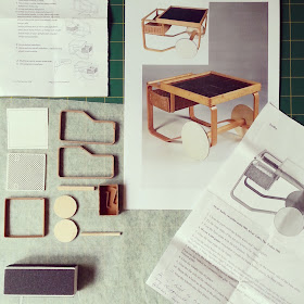 One-twelfth scale miniature kit pieces for an Alvar Aalto trolley 900, laid out with the instruction sheets and a photo of the original for reference.