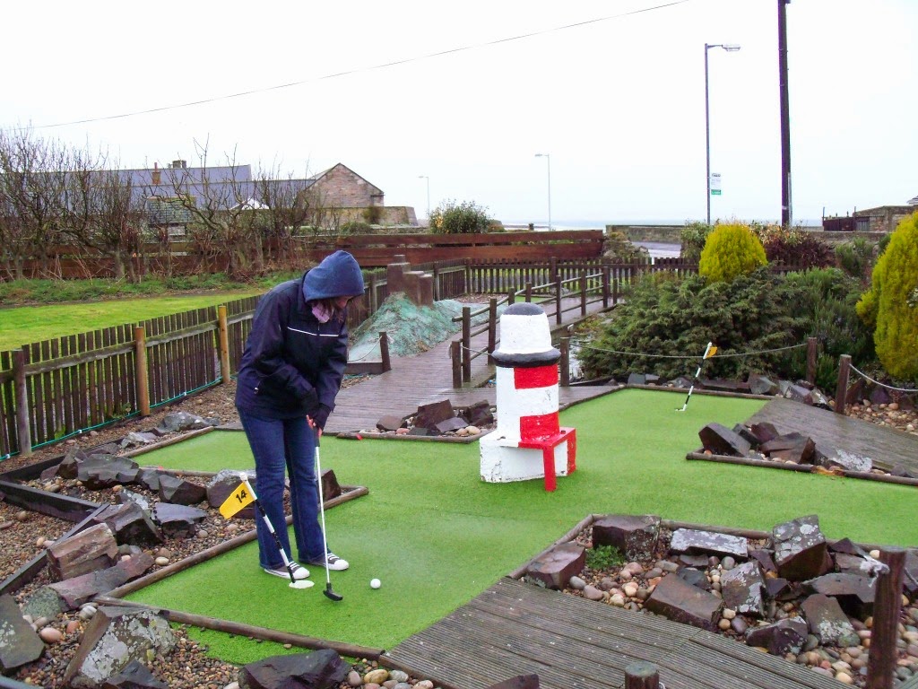 Emily playing a criss-cross of two holes at the Seahouses Crazy Golf course! Seahouses Crazy Golf
