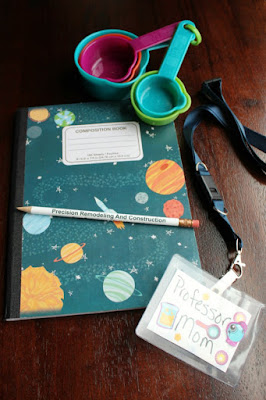 Kits of materials for a science themed party. Useful during the party and a fun party favor as well! a composition notebook, pencil, name tag and measuring cup for the science kits. not pictured: safety glasses