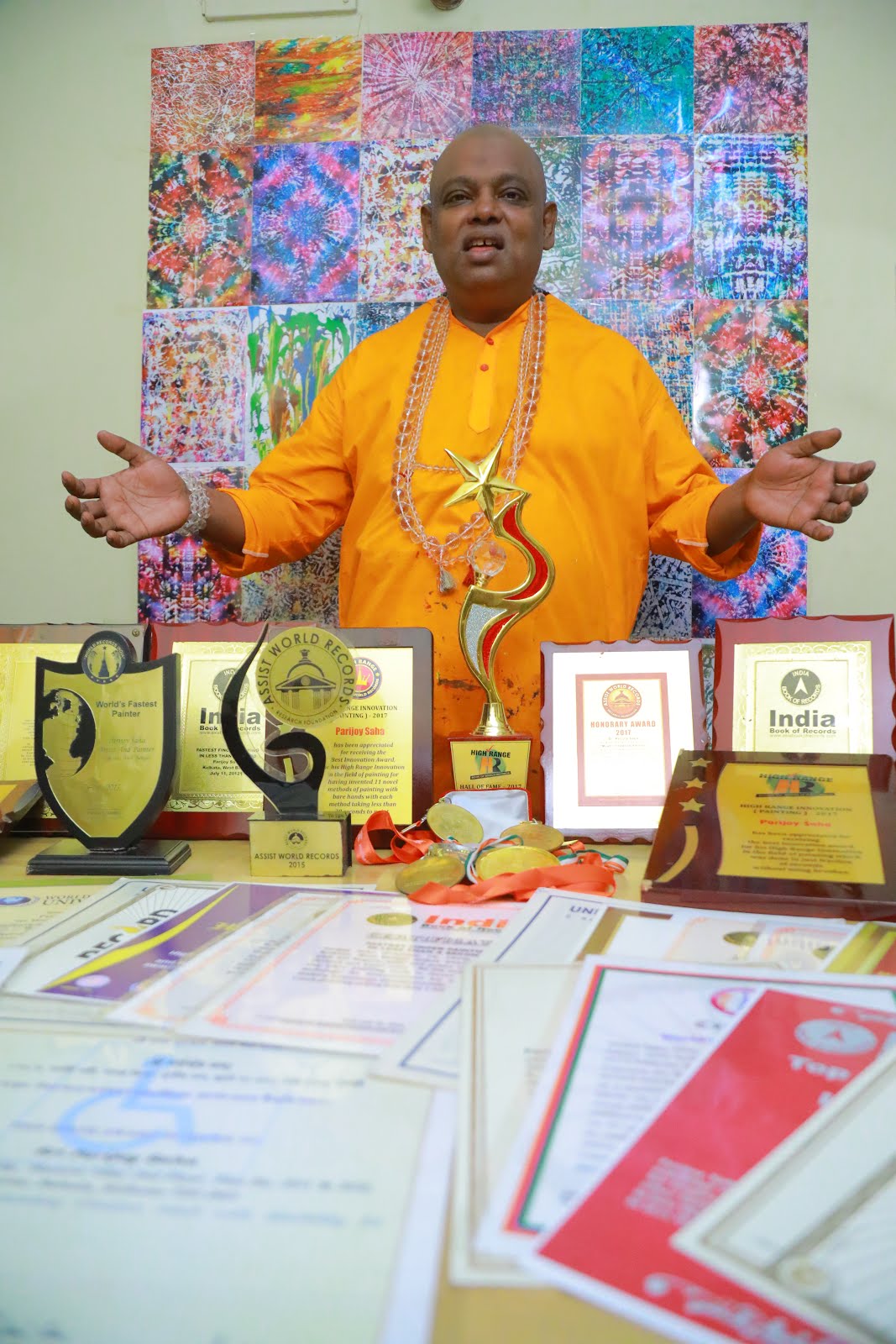 Parijoy Saha with certificates and awards.