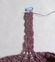 The top strap section of a tea towel top worked in a plum colour.