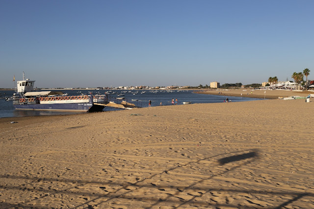 Gram playa de arena llana con un barco en la orilla.