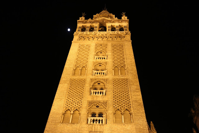 Fotografía nocturna de la Giralda en perspectiva junto a la luna Fotografía nocturna de la Giralda en perspectiva junto a la luna