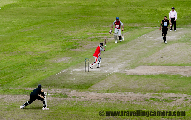 T20 Cricket Mahasangram - A Cricket Tournament that broke World Records : Postd by VJ SHARMA on www.travellingcamera.com : The Jaypee Twenty20 Mahasangram has made into the Guiness Book of World Records as the world's largest cricket tournaments. The statistics it boasts of are unbelievable. Consider the following: A total of 1,406 teams, 19,684 players, near about 2000 matches, 77 grounds on which 150 matches were played daily.I had never heard of anything like this before. And when I did hear about it, I could not resist attending the final match of the tournament. The match was also attended by Mr. Anurag Thakur, MP Lok Sabha who is also the President of Himachal Pradesh Cricket Association and a Member of the IPL Governing Coucil.This is the cricket stadium of Dharamshala situated height of 1,457 m above the sea level. With such beautiful backdrop, how do players manage to concentrate on the game? Even the stalls are so pretty. More matches should be played here. During this event, it came to know that 3 matches of upcoming IPL will be played in this beautiful Stadium...Here are the HPCA and Jaypee officials talking to media. A tournament of the size of Jaypee Twenty20 Mahasangram takes a lot of courage and co-ordination to organize. These men and their teams have been instrumental in taking the cricket scene in Himachal Pradesh to greater heights.Here is one of the finalists, the team from Mandi posing for a photograph with Mr.Anurag Thakur. I love their uniforms. I did not know red and grey could look so good together. The second finalist was the team from Una.Mandi team got to bowl first. Here is there wicket keeper grasping the ball.Here is a batsman from team Una walking back to the pavilion after being given out. Notice the dress again. Excellent combination. I think a few of the international teams can learn from the designers of these dresses.Another batsman going back to the pavilion. The excitement was increasing with each passing minute. This is the advantage of Twenty20. It is like a quick adrenaline rush. Each moment is so full of action and tension.The Umpire in the field and the HPCA and Jaypee officials sitting in the stall in the background.Superb bowling action. The wickets are black though. I don't think I have ever seen black wickets being used in cricket before this. But I may be wrong.HOWZZAAAT!! Well it's clearly out, No need to ask the third umpire for this one.And the ball is out of the bowler's hands. Whatis it going to be this time?Drinks break. I am fascinated by the colours used in the stall. Green, yellow, blue, pink so far. Very vibrant, very happy.Seems like good leg movements. At the far end, the other batsman is ready to make a run for it already. And the bowler is getting ready to stop the single.Kinley - I cannot imagine how many bottles would have been consumed during the tournament. Perhaps if they have kept a count, it can be another record broken in the Guiness Book.It is always good to pad up and to don the helmet. Just like riding a bike, cricket is a tricky business too.Very athletic. I am so glad I managed to catch this bowler in the air. He was always on a move.Looks like a fast bowler because of his height and a long run up.Another agile movement by a fielder of the Mandi team.Good fielding is as important as good bowling and good batting. It helps in restrict runs and batsmen. An agile fielding helps put pressure on the opponent team and leads them into doing foolish things.And here is oneof the men behind the official cameras. He covered most of the matches of this tournament.The view from the chief guest stall. All players seem so far away and then there are those magnificient mountains in the backgroud. A perfect view.It's now Mandi's turn to bat and here is a quick singles. Just like good fielding puts pressure on the batting team, quick singles put tremendous pressure on the fielding team. It's like psychological warfare.Running behind the ball to save the boundary. I have seen this situation in many international games but things are far more exciting in a Twenty20 match with fielders on their toes. Right now though, the batsmen of Team Mandi seem to be making them run all over the field.And its out. Team Una celebrating after one of Team Mandi's batsman is given out. HiFives, Hugs and jumping around makes the entire environment charged. Who can say that these are grown-up men?While the batsmen from Mandi were playing shots all over the field, the fielders from Una are leaving no stonesuntered and are throwing themleves on the ball.A bowler getting ready for a run up.Some of these fielders were so agile that I was wondering why they were not in the Indian Squad. And also the passion. It was amazing to see.Brightly coloured stands. Even if you look closely you cannot see the paint chipping from anywhere. Seems like everything was prepped up for this tournament and has been maintained really well. Kudos to the authority that maintains this stadium.Good leg movement there. And the ball is clearly visible against the green ground. Another achievement for the authority that maintains this ground. I would have loved to play on this. Though I am not much of a cricket player myself.Did he get it?A good attempt. These men seem to spend as much time in air as on the ground.Another good attempt. But this one made it for a four.Is this another catch?This is one active picture. The bowler just finishing his action, the batsman hitting the ball, the runner just starting his run between the wickets, and he empire standing around. All this happened in a matter if seconds. Hard to believe, isn't it? A good answer to people who say that cricket is a lazy sport.Is he going to get this? All three pairs of eyes are on the ball at this moment.And it is out. Love the tension. No wonder cricket is such a popular game in India. HPCA and Jaypee are doing a great job in making sure that young talent from HP gets enough exposure.The team from Mandi gave away their last few wickets in a quick succession resulting in the team from Una winning the tournament.It must mean so much to come on top amongst 1406 teams.And here is Mr. Anurag Thakur giving his final speech. His speech gave me answers that I was looking for. Why aren't more matches held in Dharamshala? because there aren't enough hotels and facilities that are up the the standard to host international guests. He mentioned about the huge amount of investments that are being made into promoting cricket in Himachal Pradesh and how one good stadium is already been buil. He also mentioned about the fact that whenever new stadiums will be planned they would also plan to upgrade the fascilities in the area. He mentioned about one five-star hotel being built in Dharamshala. He revealed that some (three) matches of IPL will be played in Dharamshala this time and requested people and fascilitators to co-operate so that in future, more such matches can be hosted here. This was a true sportsman speaking.I am happy to see that so  much of emphasis is being given to sports in Himachal Pradesh. If it is cricket now, it'll be some other sport later. But as long as we realize the importance of sports in our lives, we have really come several step ahead. Gone are the days when our elders would tell us 