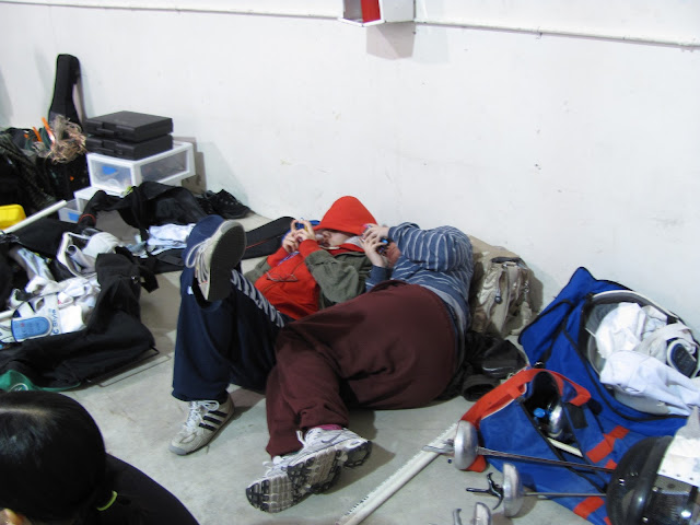 Two people lay on the floor looking at their phones