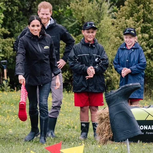 Meghan Markle wore Karen Walker Fathom dark navy jacket, Jessica McCormack Tattoo diamond pendant, Muck Boot Company