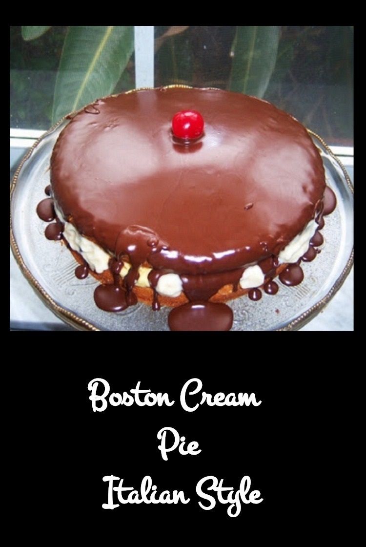 Rich golden cake with Italian pastry cream filling and chocolate ganache on top on a pedestal cake dish with a cherry in the middle of the cake