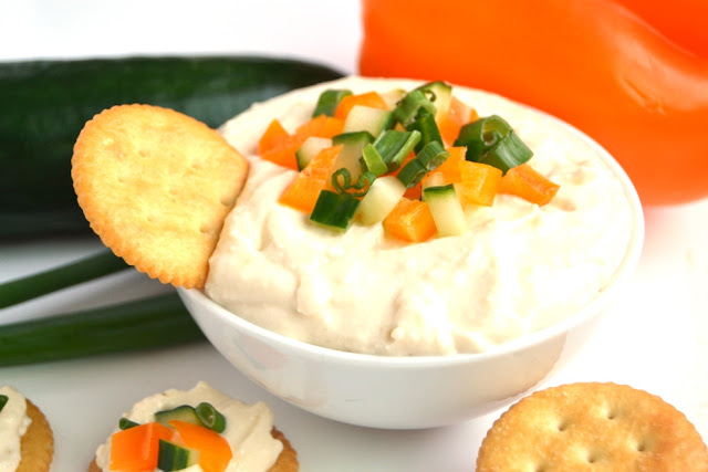 White Cheddar Horseradish Dip is ready in 5 minutes, has just 4 ingredients and is full of flavor with sharp white cheddar cheese and tangy horseradish! Topped with finely diced vegetables and served with crackers for an easy appetizer. www.nutritionistreviews.com