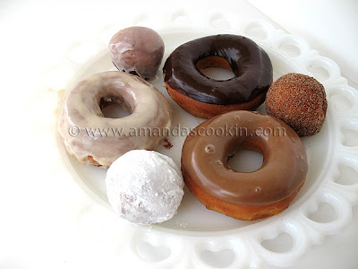 A photo of a plate of an assortment of homemade doughnuts.
