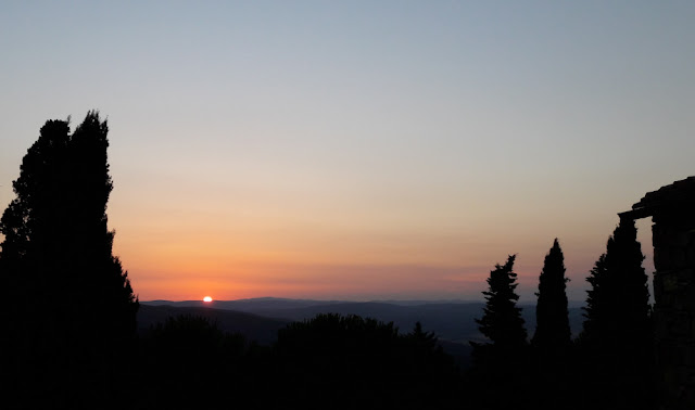 Cypress trees and Tuscan hills at sunset