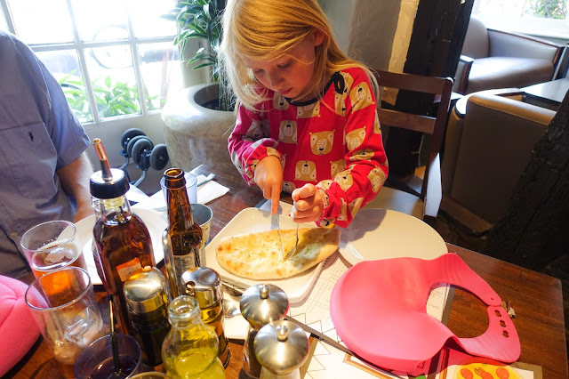 A young girl cutting garlic bread at Prezzo