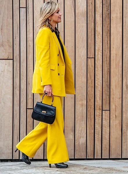 Queen Maxima wore a yellow blazer and trousers from Zara, Cartier gold bamboo earrings, carries Susan Gail bamboo handle handbag