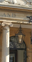 Close-up of a Georgian pillar with the word "and" and the edge of a black sign