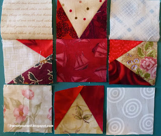 Layout of red and cream nine-patch block showing three pairs of squares sewn with chain piecing intact between them.