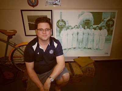 Former museum summer student poses with photograph