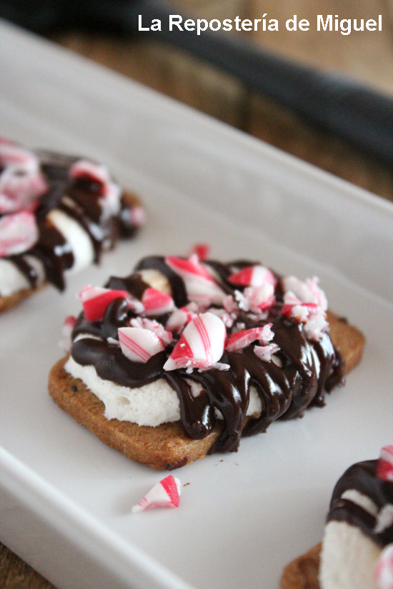 Un pequeño dulce formado por una galleta con una nube de azúcar encima fundida al horno, un poco de chocolate negro fundido y trocitos de caramelo. 