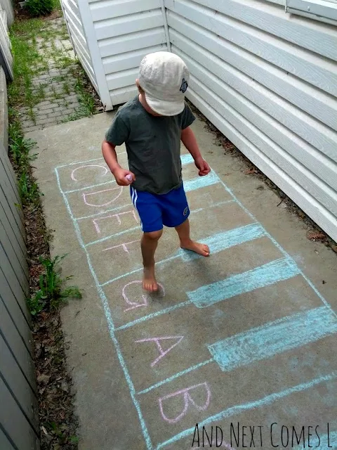Child standing on a chalk piano with letters on it