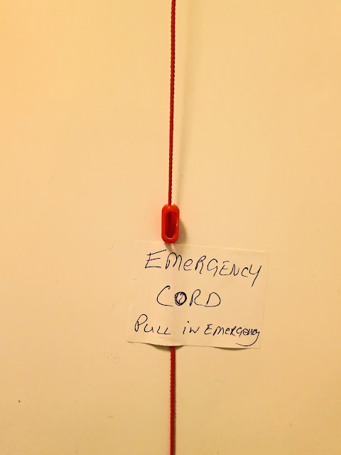 Red emergency cord with handwritten instructions - EMERGENCY CORD Pull in Emergency