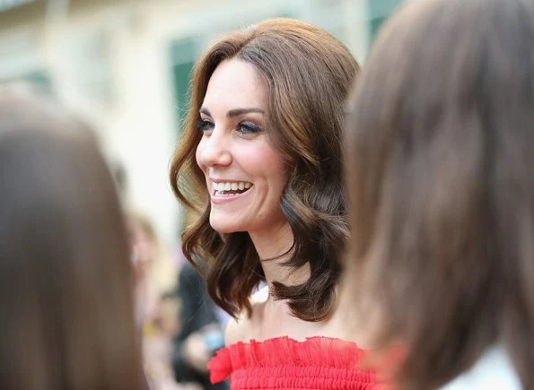 Kate Middleton's dress is by Alexander McQueen Off-the-shoulder shirred cotton and silk-blend. Simone Rocha Crystal earrings, Prada Pumps, Club Monaco Channon Heeled Sandal