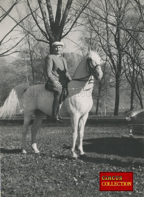 Fredy Knie senior posant sur sa monture blanche dans les champ de la campagne de Rapperswil