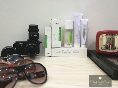 A set of Swissvita anti acne solutions on a table with a nikon V1 camera, 3 sunglasses