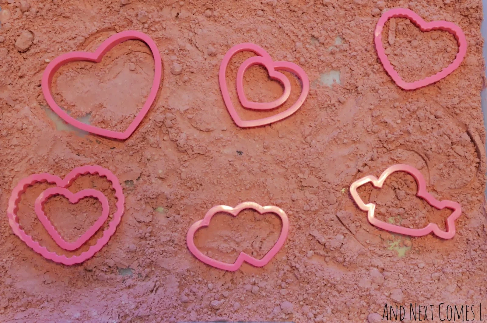 Cinnamon heart cloud dough and heart cookie cutters for Valentine's Day sensory play from And Next Comes L