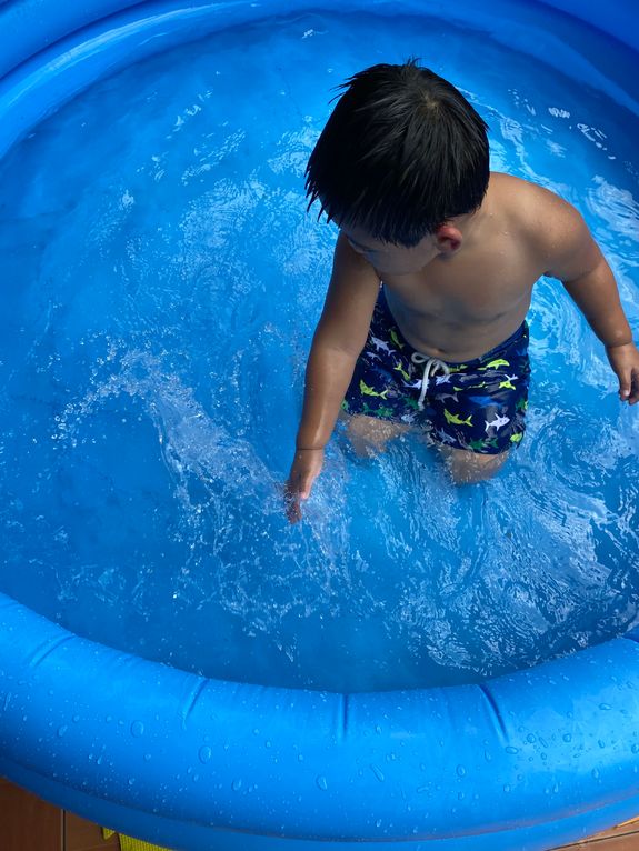 Little boy loving the water in an inflatable kiddie pool