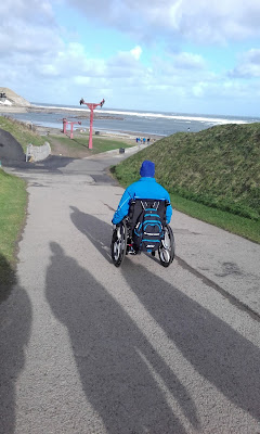 Photo of me pausing at the top of a steep hill down to the beach.