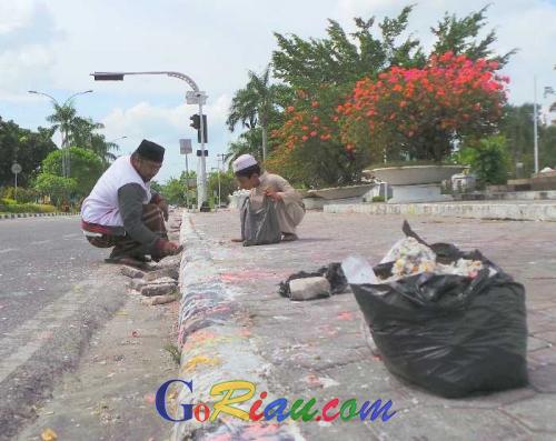 Mantap ! Pria Ini Ajak Anaknya Umur 9 Tahun Bersihkan Kerak Lilin Pro-Ahok yang Kotori Tugu Perjuangan Pekanbaru