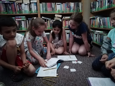 Dzieci słuchają koleżanki czytającej książkę