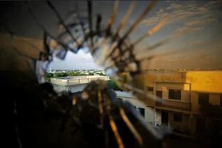 Skyline beyond the northern suburbs of Mogadishu is seen through a bullet hole