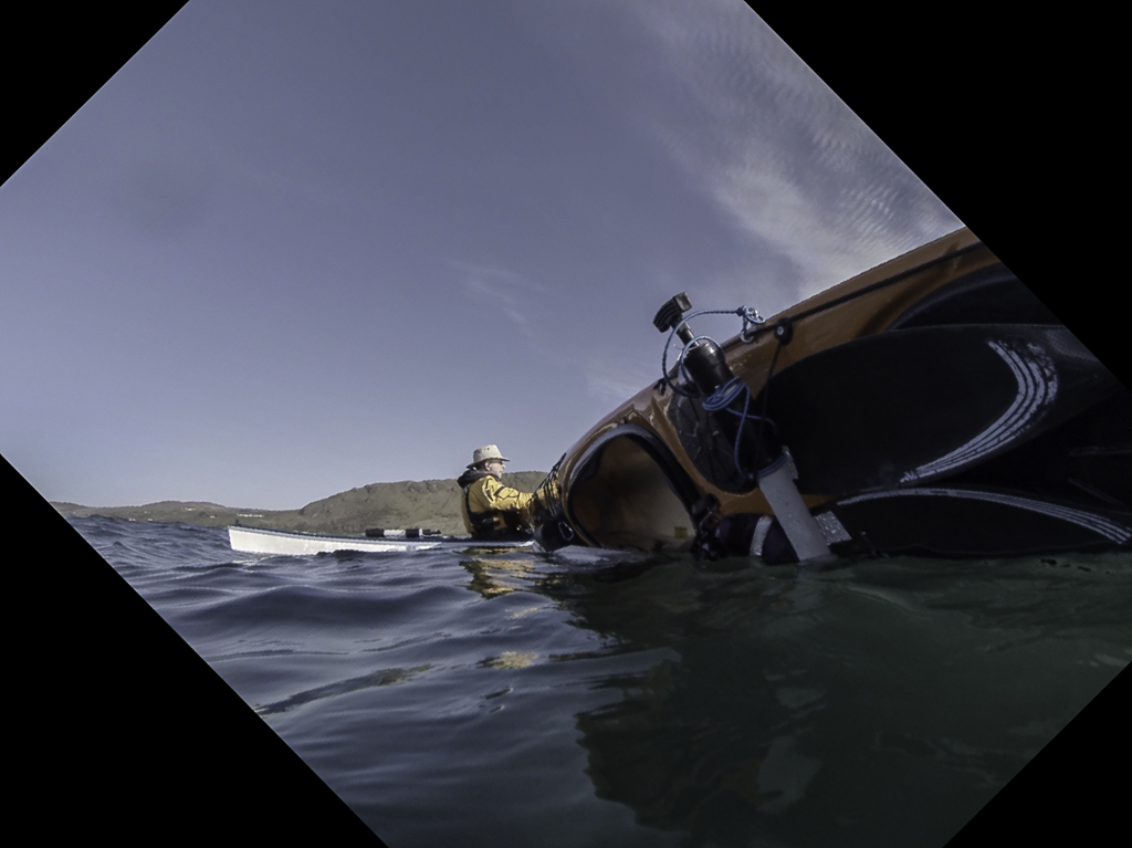 Sea kayaking with Assisted reentry after a capsize with a Flat Earth kayak sail.