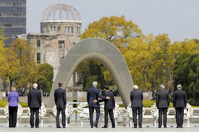 U.S. Secretary of State John Kerry puts his arm around Japan's Foreign Minister Fumio Kishida after they and fellow G7 foreign ministers laid wreaths at the cenotaph at Hiroshima Peace Memorial Park and Museum in Hiroshima, Japan, From ImagesAttr