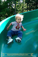 1 year old boy sliding down a twisty slide