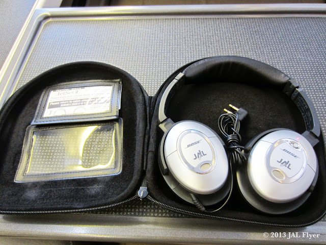 JAL First Class: Customized Bose QuitComfort 2 headphones with JAL logos on them.